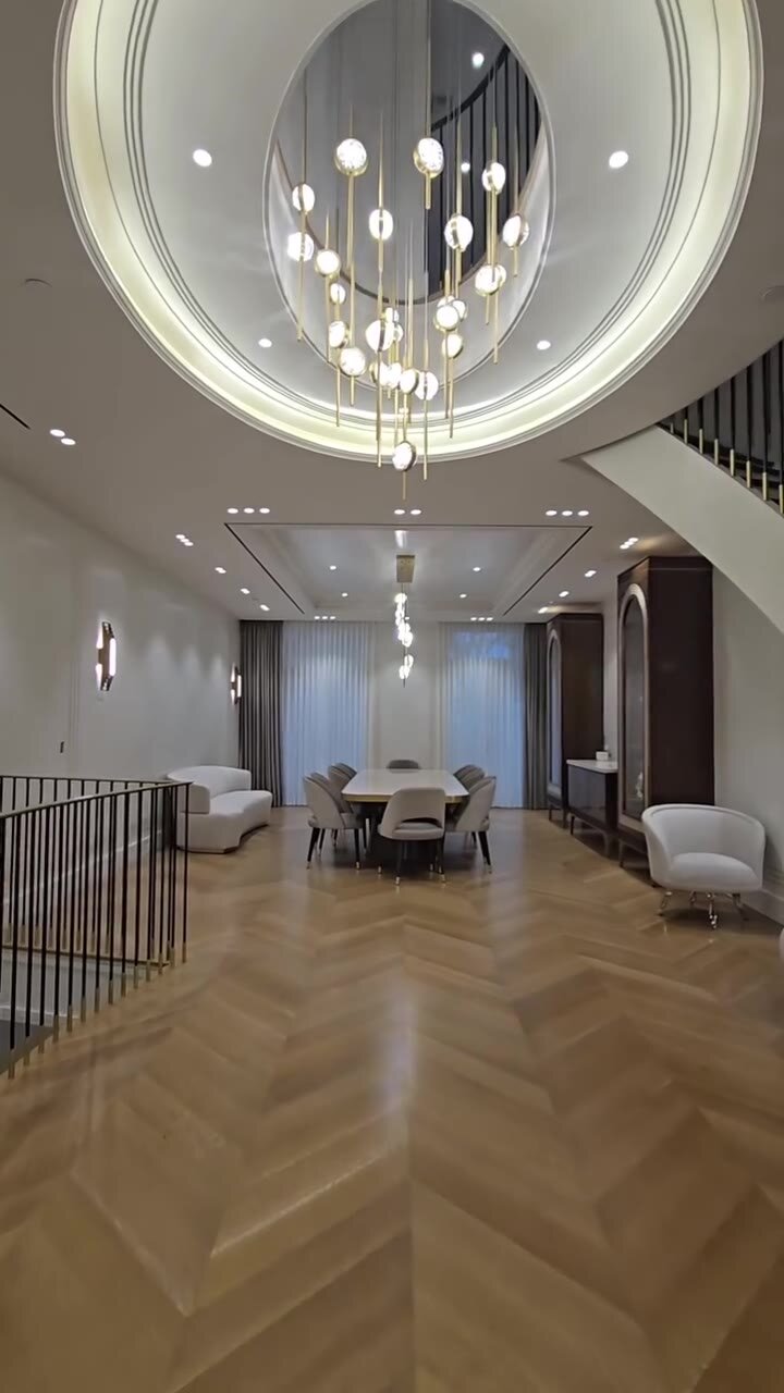 Dining area with oval mirrored ceiling detail, globe chandelier and herringbone oak floor