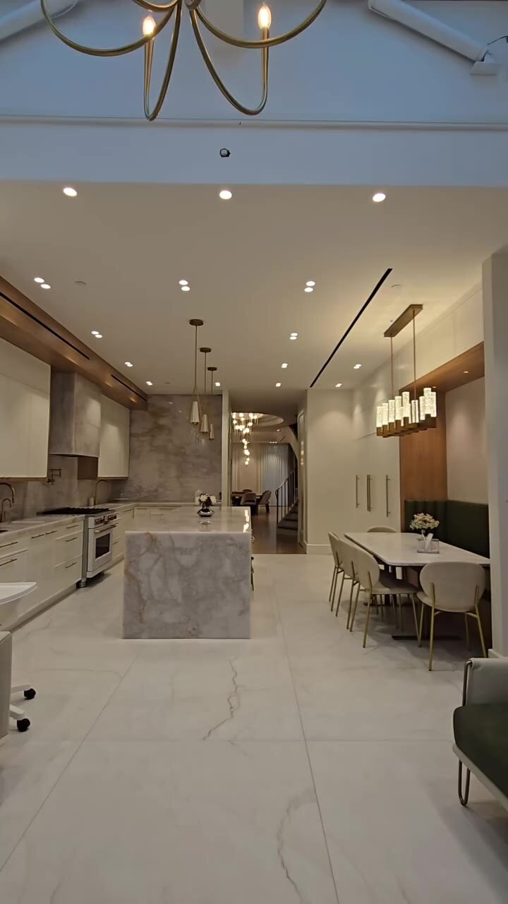 New marble waterfall island kitchen under a skylight